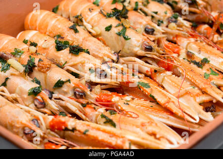 Scozzese, scampi Nephrops norvegicus, acquistato da un supermercato e fotografato su una piastra dopo aver fritto nel burro e aglio e prezzemolo. La lang Foto Stock