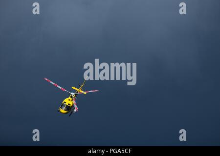 Giallo elicottero volando isolato nel cielo. Sfondo drammatico con spazio di copia Foto Stock