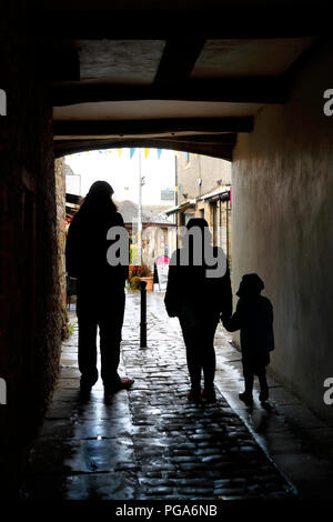 Si ripara dalla pioggia in un vicolo di modo in Skipton Foto Stock