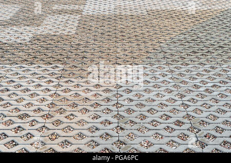 Wet openwork pavimentazione in calcestruzzo riempiti con ciottoli colorati. Foto Stock