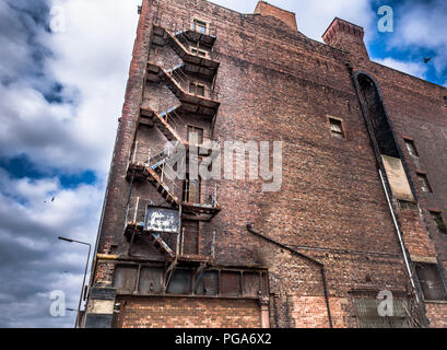 Vecchio di ferro arrugginito sulla scala di un magazzino abbandonato a Liverpool docks. Foto Stock