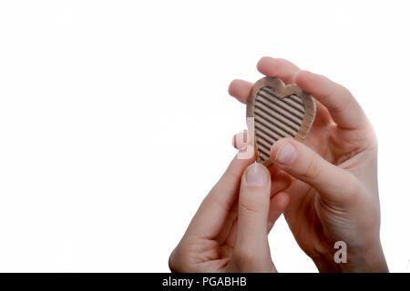 Cuore isolato di forma foro attraverso il cartone in mano Foto Stock