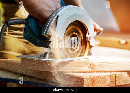 Nuovo home progetto constructiion imprenditore edile lavoratore utilizzando tenuto in mano unità worm sega circolare per il taglio di pannelli Foto Stock