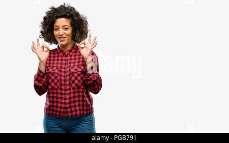 Bella donna araba facendo segno ok gesto con entrambe le mani che esprimono la meditazione e relax Foto Stock