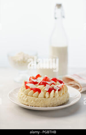 Delicato Strawberry Cheesecake con noce di cocco. Deliziosi dolci fatti in casa con frutti di bosco freschi sul tavolo luminoso. Foto Stock