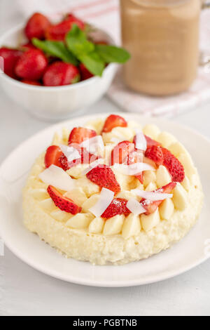Delicato Strawberry Cheesecake con noce di cocco. Deliziosi dolci fatti in casa con frutti di bosco freschi sul tavolo luminoso. Foto Stock