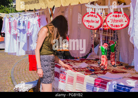 A Cluj Napoca, Romania - 29 luglio 2018: donna scegliendo asciugamani ricamati a etnica negozio di souvenir Foto Stock