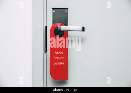 Si prega di non disturbare rosso etichetta appesa in camera di albergo manopola dello sportello Foto Stock