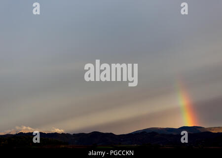 Bellissimo e surreale vista di parte di un arcobaleno su alcune colline Foto Stock