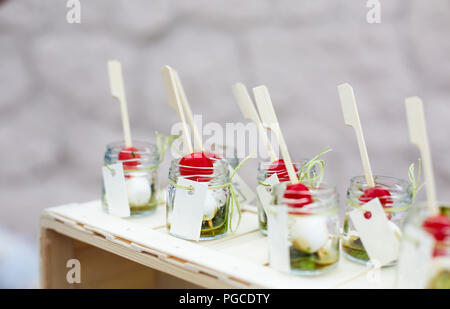 Italiana fresca insalata caprese con mozzarella e pomodoro in vasetti. Finger food catering sul caso. Messa a fuoco poco profonda Foto Stock