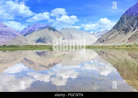 Bella riflessione catturati nel lago calmo su Leh Turtuk road. Nuvole, cielo blu aggiungere dram nell'immagine. Foto Stock