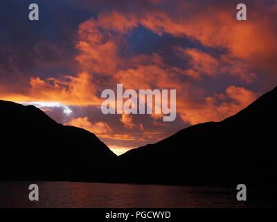 Nuvole evidenziato dal tramonto su Crummock acqua, Buttermere Valley, Parco Nazionale del Distretto dei Laghi, Cumbria, England, Regno Unito Foto Stock