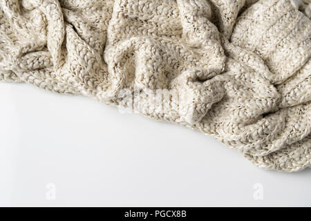 Coperta di lana, bianco di grandi dimensioni di maglia chunky filato. Close-up di coperta di maglia su sfondo bianco. Foto Stock