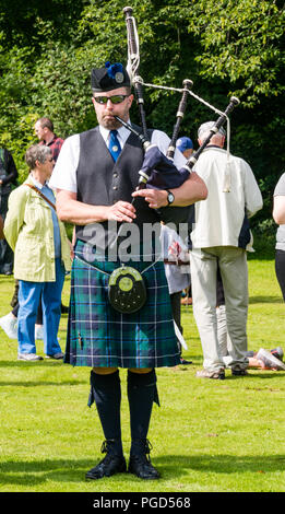 Haddington, Scotland, Regno Unito. Il 25 agosto 2018. Haddington 700 medievale celebrazioni grande giornata Giornata medievale è il momento clou di Haddington 700 gli eventi che avranno luogo nel 2018 per celebrare la concessione di una carta da Robert the Bruce alla città nel 1318, confermando Haddington il diritto di tenere un mercato e raccogliere la dogana. Un suonatore di cornamusa in Haddington Pipe Band suona la cornamusa su East Haugh Foto Stock