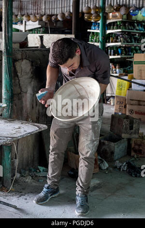 Hebron, Palestina, Giugno 4, 2014: giovani palestinesi lavora in un laboratorio di argilla che produce utensili domestici. Foto Stock