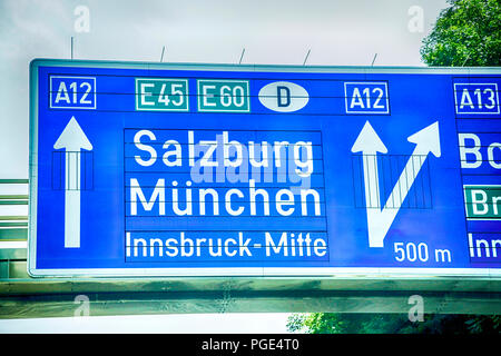 Big Blue tettuccio di cartello autostradale con frecce bianche dirigere traffico verso Salisburgo o Berlino su A12, A13 Foto Stock