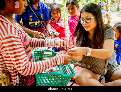 Signora cambogiano di acquistare da bambini in countrysdie vicino a Siem Reap. gen. 2016, campagna Siem Reap, Camboida. Chhorpoan buing ninnoli da C Foto Stock