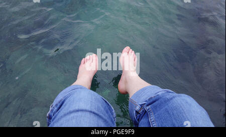 Coppia di piedini caucasica appesa sopra il mare verde Foto Stock