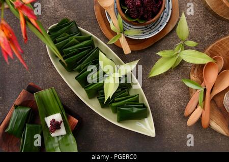 Tape uli, il duo snack di nero fermentato riso glutinoso (nastro) e sapido vapore riso glutinoso torta in foglia di banano (Uli). Foto Stock