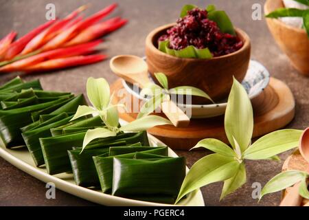 Tape uli, il duo snack di nero fermentato riso glutinoso (nastro) e sapido vapore riso glutinoso torta in foglia di banano (Uli). Foto Stock