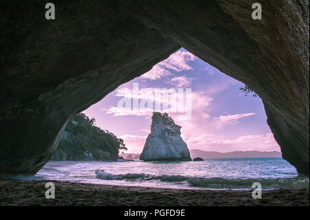 Tramonto, Cove della cattedrale, Penisola di Coromandel, Nuova Zelanda. Vista attraverso il rock arco verso Te Hoho Rock Foto Stock