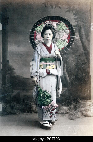 [ C. 1890 Giappone - Geisha con Parasol ] - donna giapponese in kimono tenendo un ombrellone e fiori. Testo originale: "Un Costume Estate.' albume fotografia originati da Kozaburo Tamamura (1856-1923?), 1890, per " Giappone, descritta e illustrata dal giapponese', Shogun edizione a cura di capitano Brinkley F. Pubblicato nel 1897 da J B Miglio Company, Boston Massachusetts, STATI UNITI D'AMERICA. Xix secolo albume vintage fotografia. Foto Stock