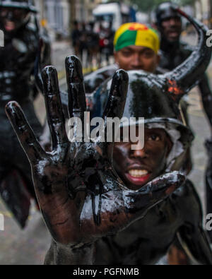 Londra, Regno Unito. 26 Ago, 2018. Jouvert, presto al mattino che coinvolgono farina colorata, olio e vernici - La domenica del carnevale di Notting Hill. La manifestazione annuale sulle strade del Royal Borough di Kensington e Chelsea, oltre a ferragosto weekend. Esso è guidato dai membri della British West comunità indiana, e attira circa un milione di persone ogni anno, il che lo rende uno dei più grandi del mondo street festival. Credito: Guy Bell/Alamy Live News Foto Stock