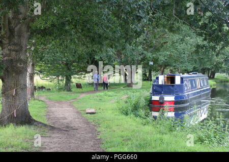 Vista posteriore di due escursionisti su un argine con un ormeggiati houseboat Foto Stock