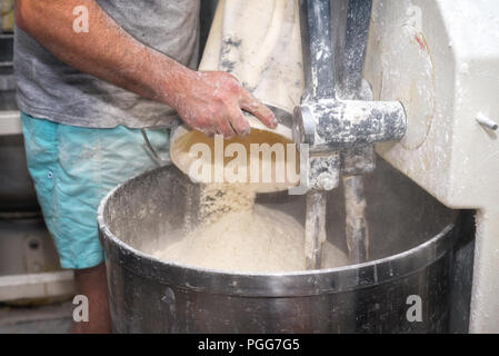 Caricamento di farina in un panificio industriale impastatrice. Foto Stock