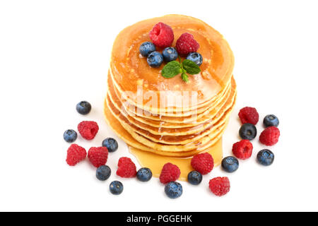 Frittelle pila con diversi frutti di bosco e miele isolati su sfondo bianco. Foto Stock