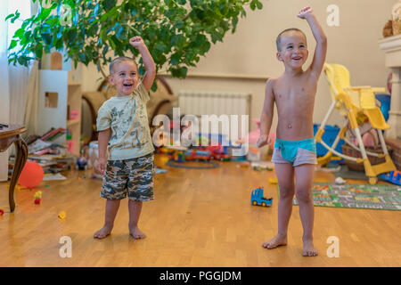 Due ragazzini sono a fare gli esercizi. Due bambini piccoli a casa facendo sport. I bambini fanno esercizi. Due ragazzini sono a fare gli esercizi. Il concetto di Foto Stock