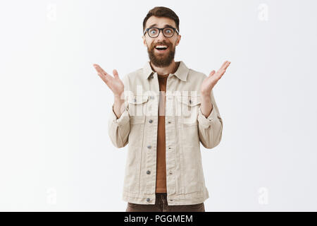 Piacevolmente sorpreso molto bella ed elegante tanga adulto ragazzo con barba lunga e taglio di capelli eleganti palme di sollevamento con gioia e sorrisi di felicità e di stupore vedere amico inaspettatamente Foto Stock