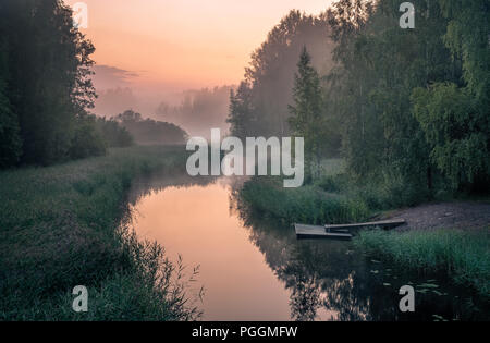 Idillica vista sul fiume con Pier e nebbioso tramonto a notte estiva in Finlandia Foto Stock