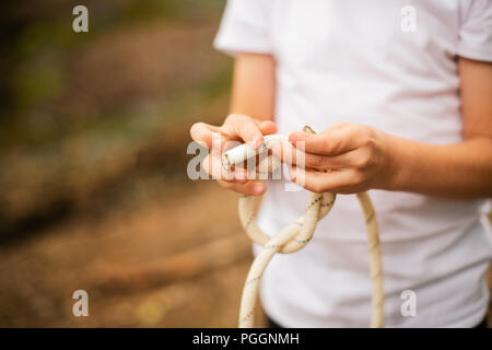Ragazzo nodo di legatura in corda Foto Stock