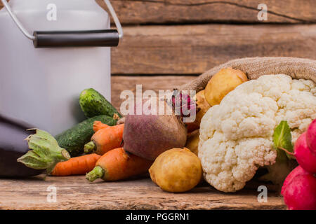 Enamelware bidone di latte e verdura vicino. Ancora in vita. Il cavolfiore, barbabietole, le patate e le carote. Foto Stock