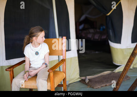 Bambina in tenda safari godendo di vacanza di lusso in Africa Foto Stock