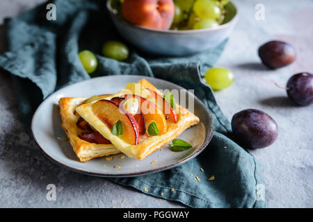 Frutto della pasta sfoglia torte con fette di pesche, susine e uva Foto Stock