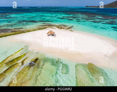 Antenna vista drone di minuscoli Mopion tropicale isola sandbar, turchese del mare dei Caraibi e una famiglia con bambini a St Vincent e Grenadine Foto Stock