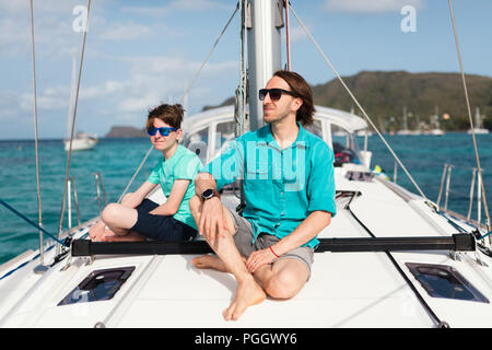 Il padre e il suo figlio adolescente a bordo di yacht a vela avente estate Viaggi avventura Foto Stock