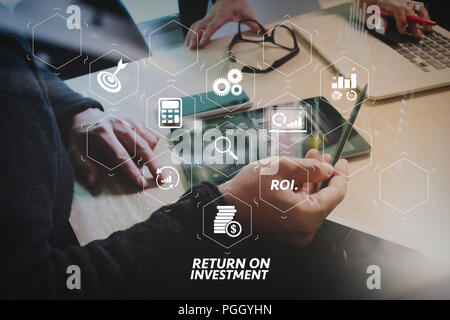 ROI più elevato ritorno sugli investimenti spia nel cruscotto virtuale per migliorare il business. Riunioni di team aziendali presenti. Foto di investitore professionale lavorando wit Foto Stock