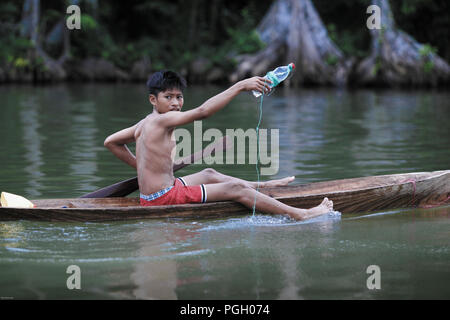 La pesca del ragazzo dalla canoa di legno a Monterrico, Guatemala Foto Stock