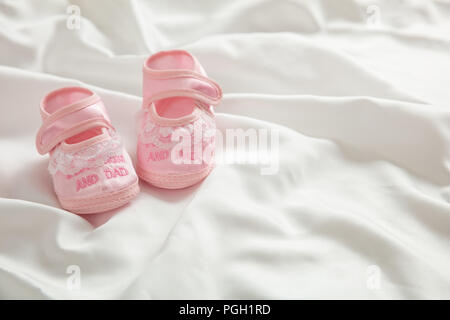 Bambina scarpe, doccia invito concetto su white satin, spazio di copia Foto Stock