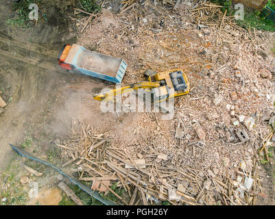 Foto aerea di demolizione urbana sito. escavatore lavora in rovine e macerie Foto Stock