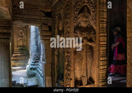 Una donna cammina attraverso uno dei numerosi corridoi al Preah Khan Temple a Siem Reap, Cambogia Foto Stock