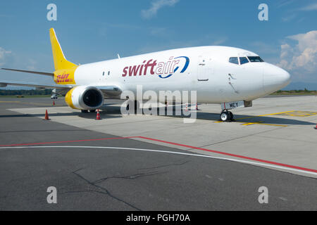 Brnik, Slovenija - Agosto 23 2018: Swift Air Boeing B737 giallo con logo DHL sulla coda presso l'aeroporto di Lubiana in attesa per il trasporto di merci su strada asfaltata. Foto Stock