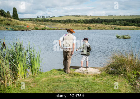 Nonno e nipote di pesca in Thunton lunga falesia di pesca di trote, Thrunton, Northumberland, Inghilterra, Regno Unito. Foto Stock