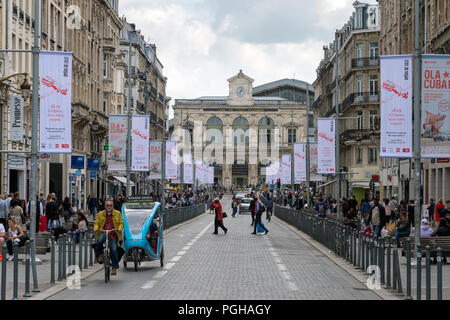 Lille, Francia - 15 Giugno 2018: il traffico e la gente che camminava sul Faidherbe Street. Stazioni ferroviarie di Lille-Flandres railroad station sullo sfondo. Foto Stock