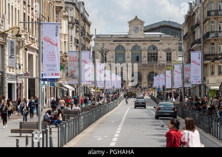 Lille, Francia - 15 Giugno 2018: il traffico e la gente che camminava sul Faidherbe Street. Stazioni ferroviarie di Lille-Flandres railroad station sullo sfondo. Foto Stock