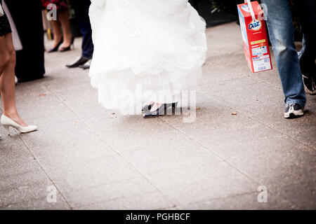 Close up di spose in piedi di distanza e l'uomo con scatola di Daz il detersivo in polvere Foto Stock