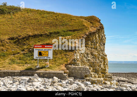 Vista del paesaggio di un segno a fianco di scogliere di visitatori di avvertimento alla spiaggia di Llantwit Major del rischio di caduta di sassi. Foto Stock